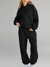Plus size Tikibella™ full size hoodie and joggers set with a kangaroo pocket, displayed in a casual setting.